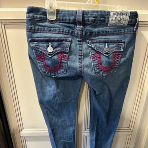 True Religion jeans with magenta stitching.